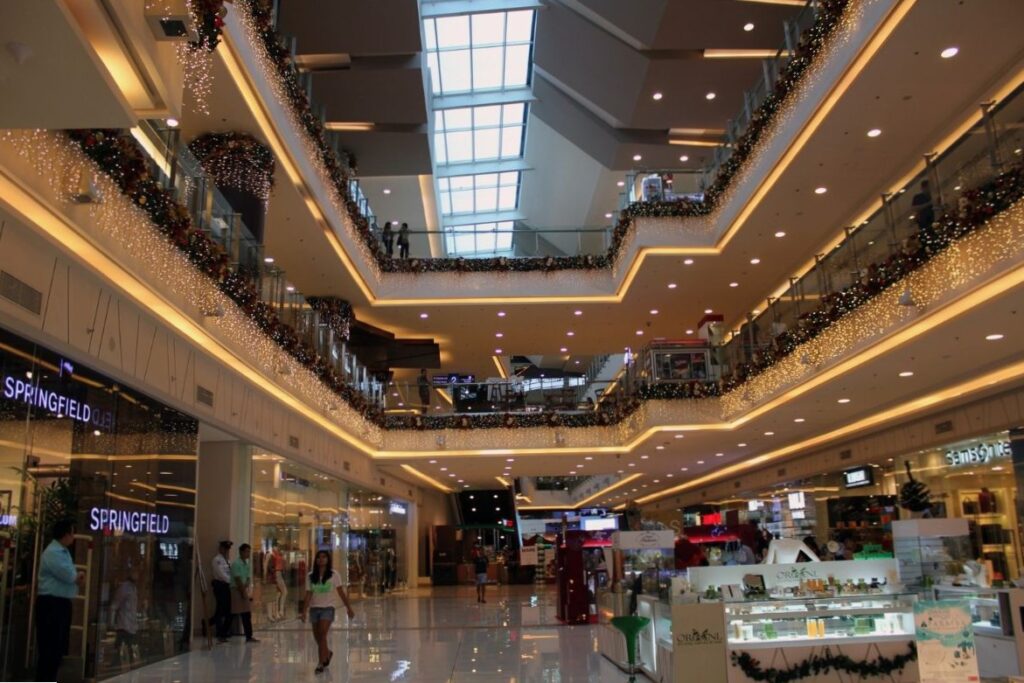 Multi-level indoor shopping mall with holiday lights stung up
