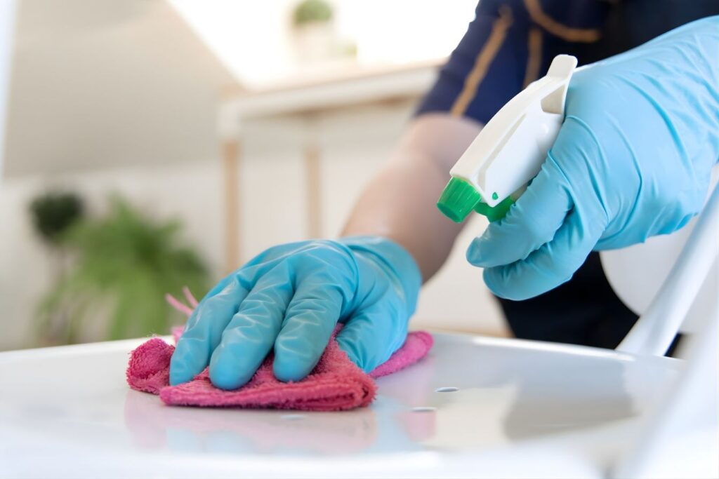Medical cleaning service spraying and cleaning a chair
