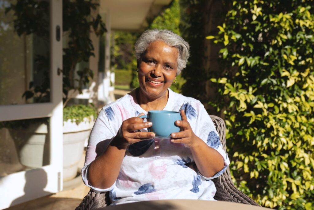 Elderly woman sipping tea on a porch