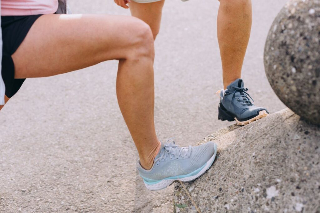 2 women doing leg stretches before going for a walk