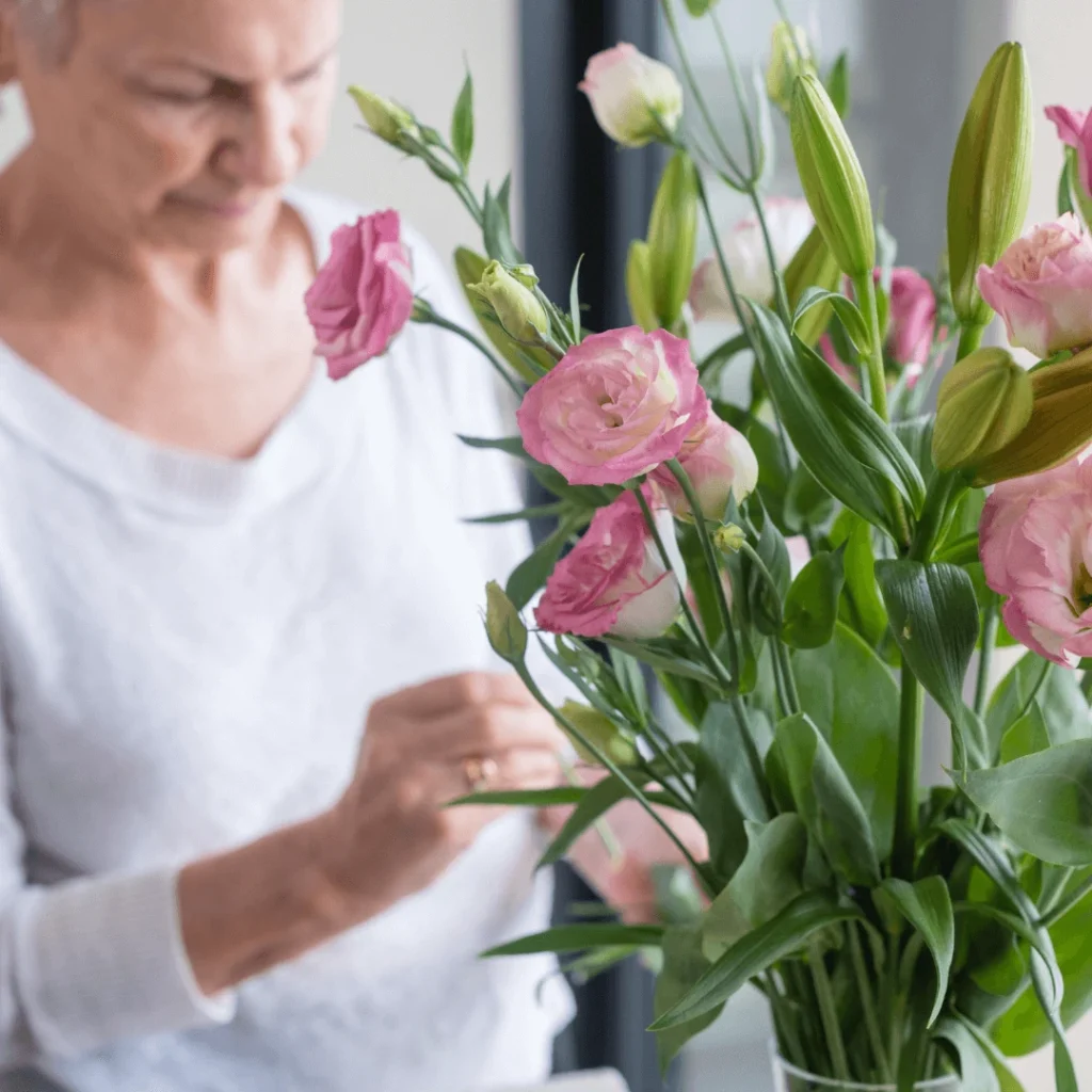 A female senior citizen arranges flowers which helps mental stimulation