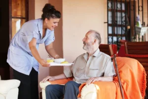 Home care agency aide from Happier At Home brings meal to an elderly man