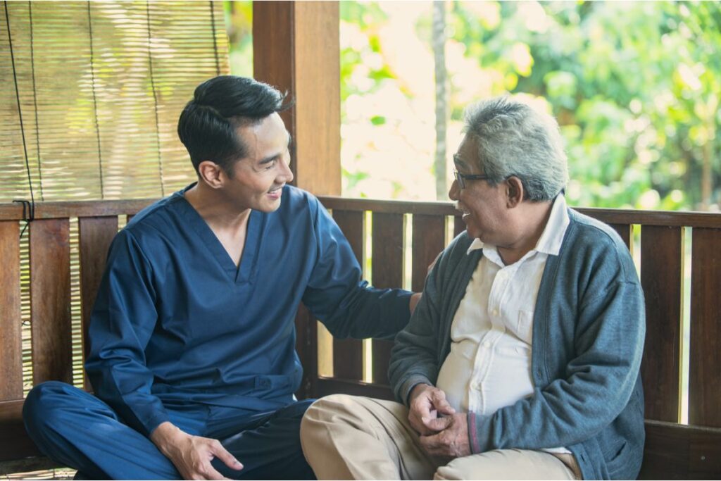 In-home care assistant sitting on a porch with an elderly man