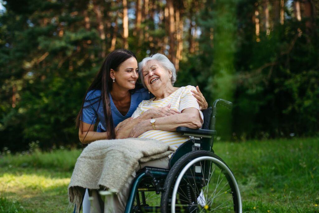 woman taking her elderly mother for a walk in the park